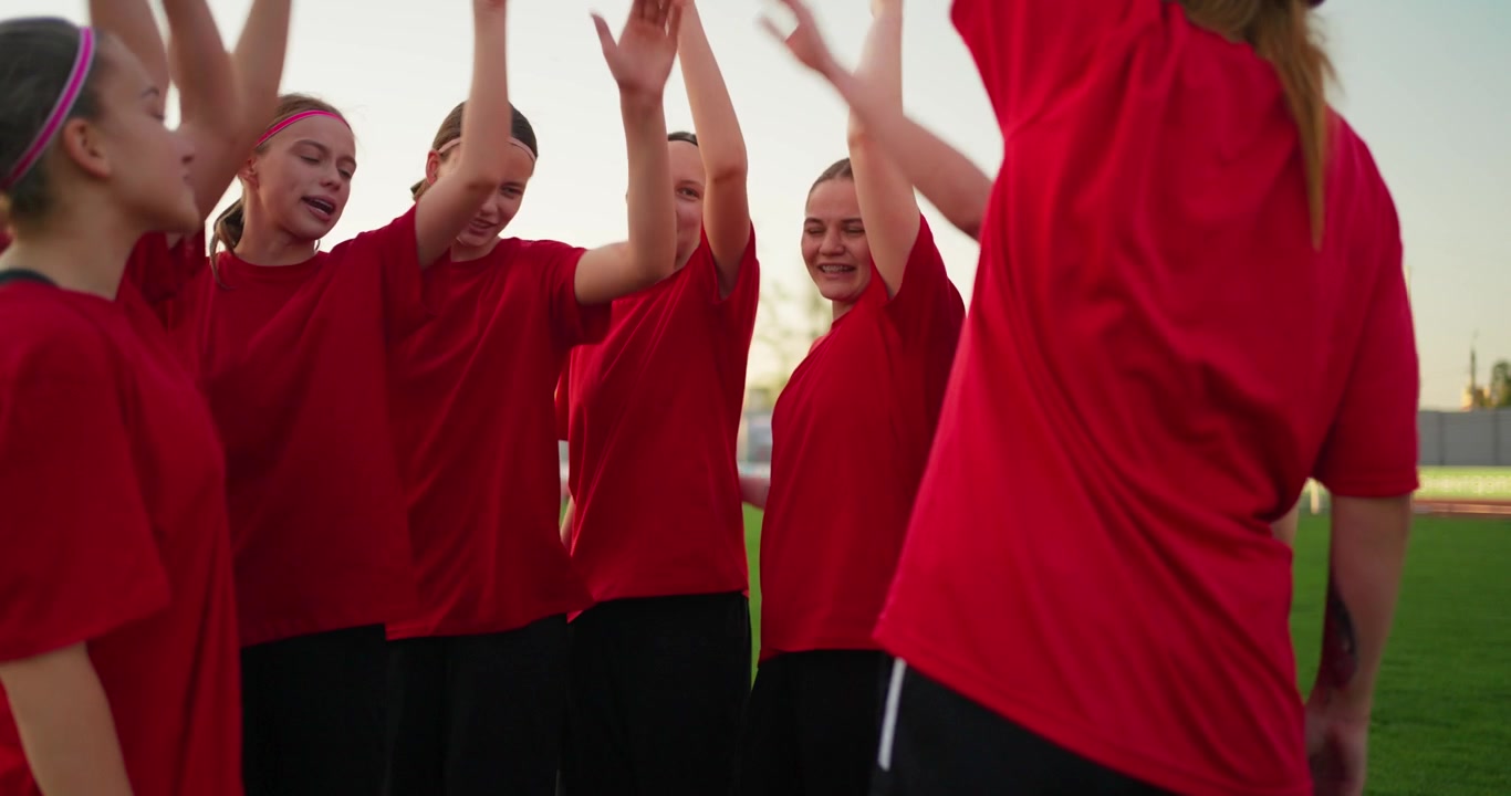 Young Female Athletes Huddle and Celebrate Teamwork