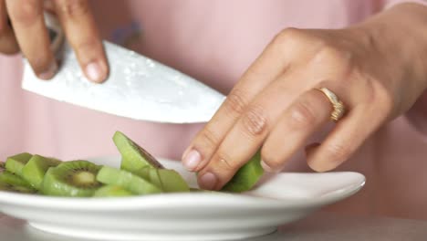 woman cutting kiwi fruit