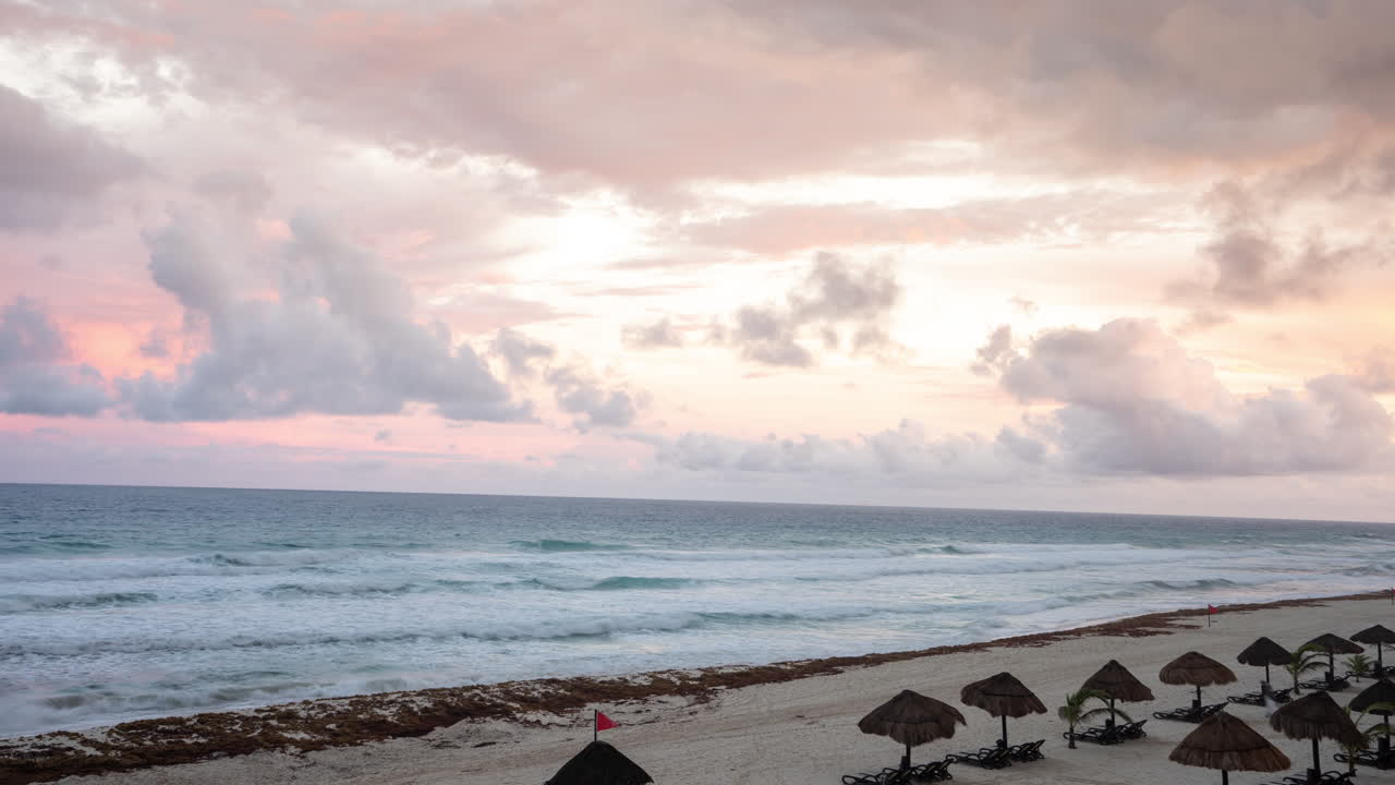 Time-lapse del atardecer en la playa de Cancún, México. Nubes en movimiento sobre el mar y la playa de arena blanca