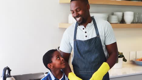 smiling father and son standing together in kitchen