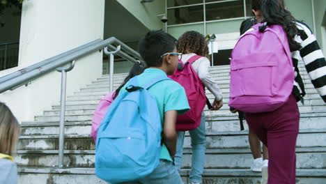 Multiethnic-group-of-schoolkids-of-different-ages-going-up-stairs