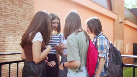 las adolescentes se divierten y conversan usando sus teléfonos móviles