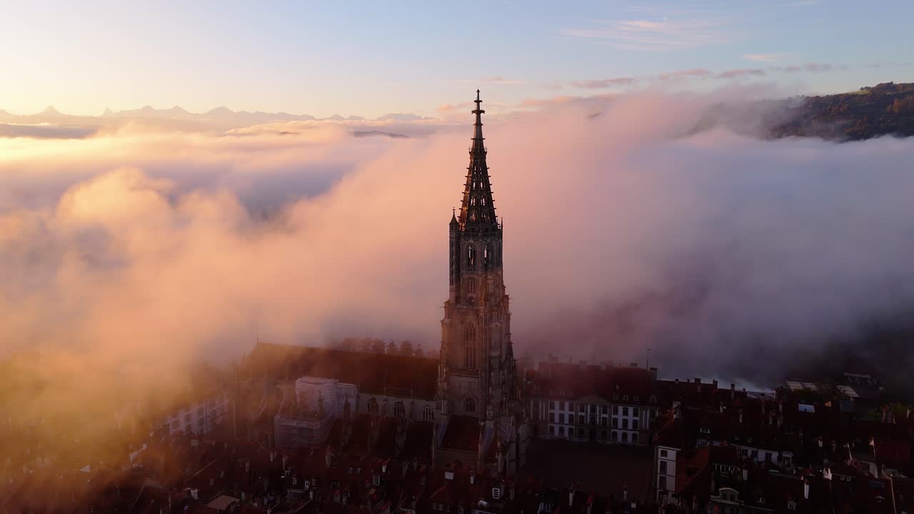 Droneflight over the old city of Bern during fog and sunrise with the Münster Church.