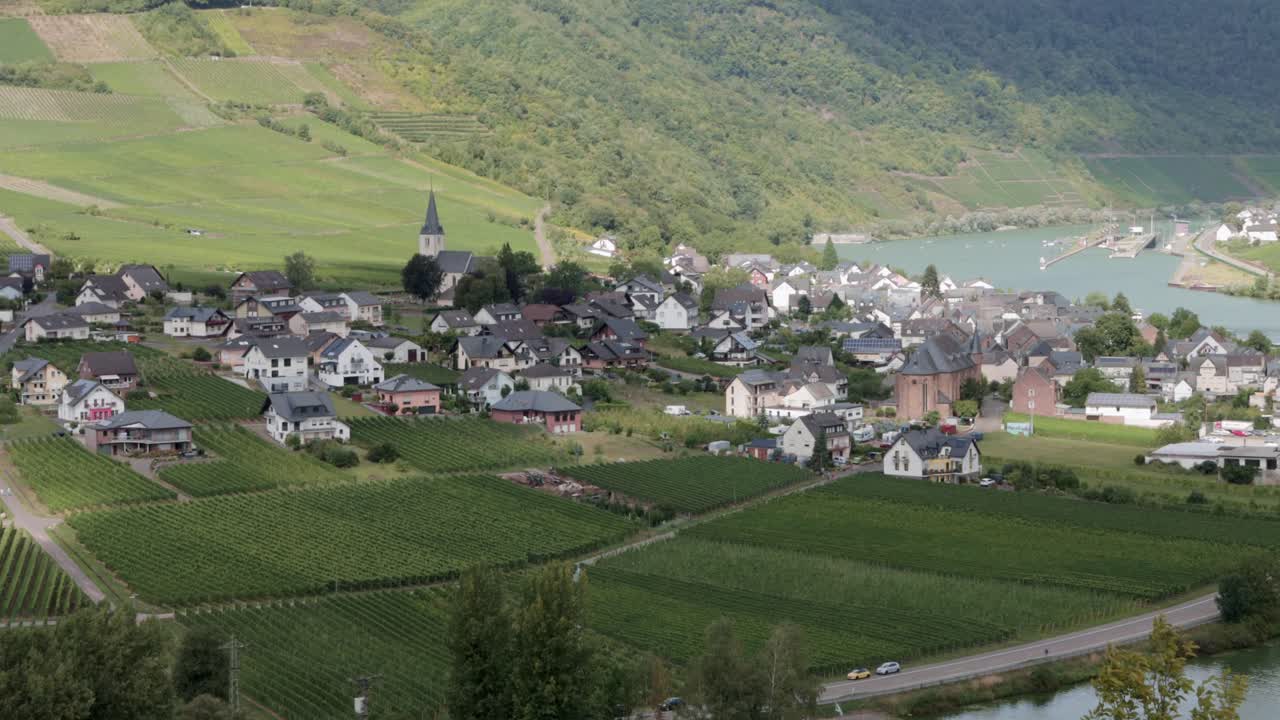Small european town on the Mosel river valley surrounded by vineyards, static shot