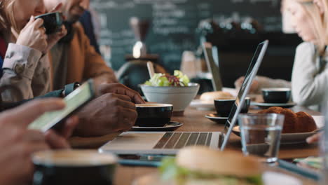 businessman hands using laptop computer in cafe typing emails working online enjoying drinking coffee relaxing on lunch in busy restaurant