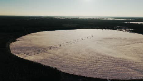 aerial view of a large circular field blanketed in snow with a central irrigation pivot, captured during a slow left-oscillating drone movement after south georgia's rare snowfall.