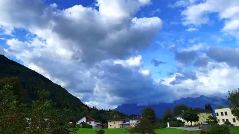 Footage-of-a-twirling-heavy-clouds-over-the-mountain-and-residential-houses-on-the-foreground