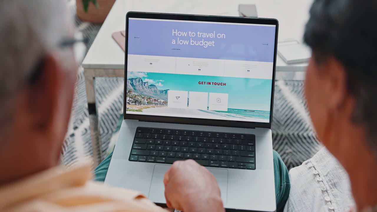 una pareja de mayores planean un viaje en una computadora portátil