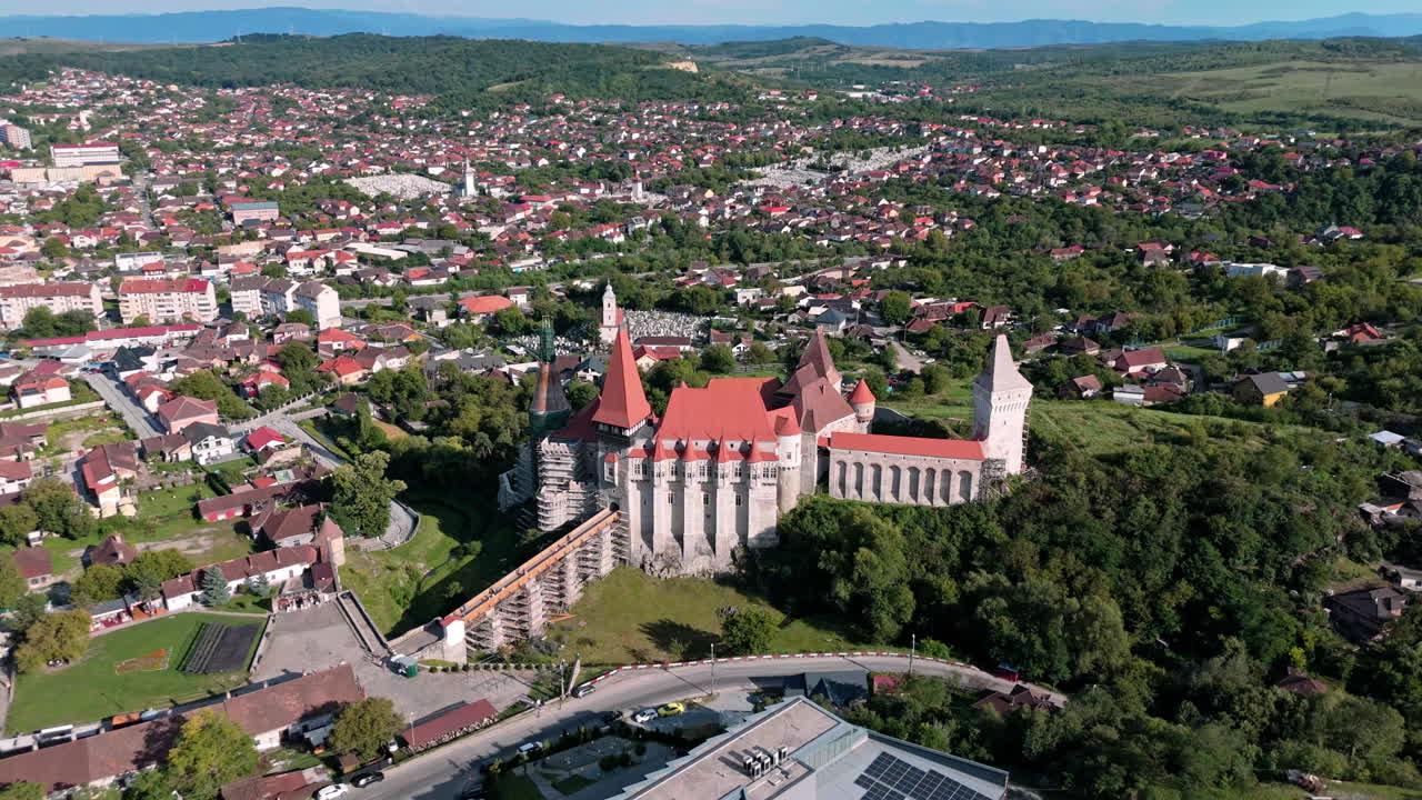 Aerial view of Corvin Castle and Hunedoara on a sunny day, historic ambiance