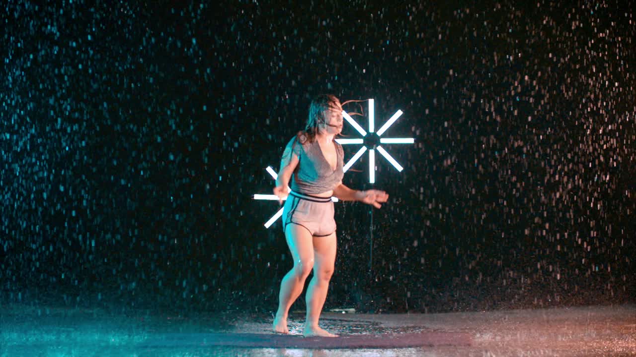 Female dancer performing in slow motion rain, modern hip hop dancing