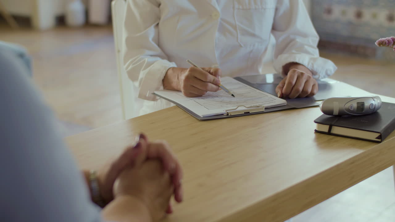 Primo piano di un medico che prende appunti sulla salute dei pazienti a domicilio.