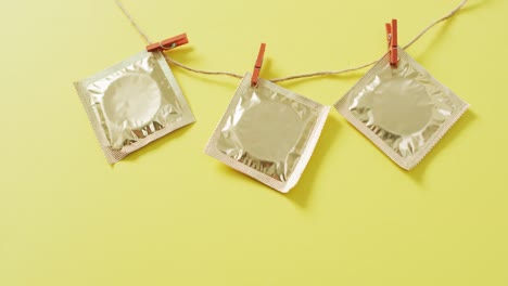 video of close up of condoms hanging on green background