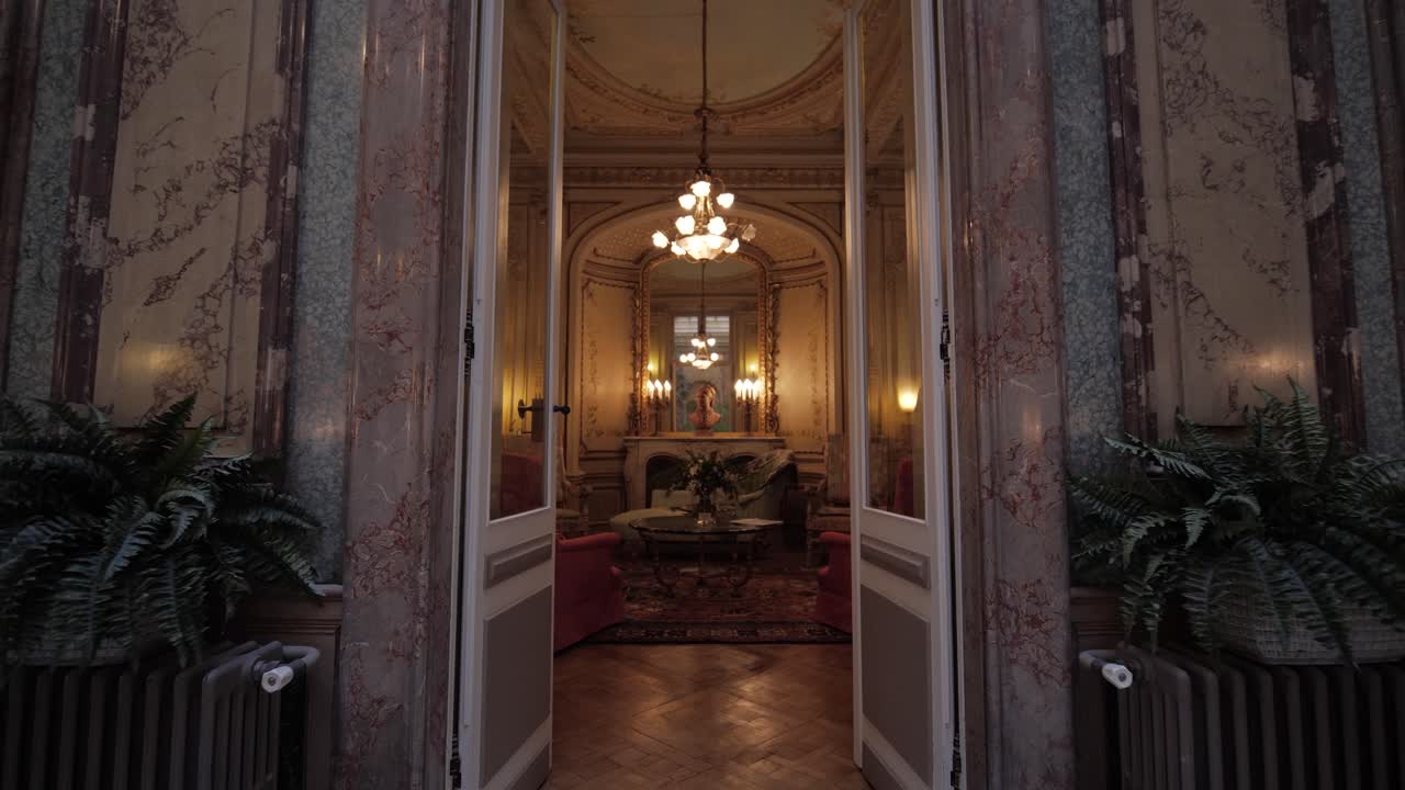 이중 출입구를 통해 멋진 라운지 공간으로 걸어가는 슬로우 포워드 돌리 샷