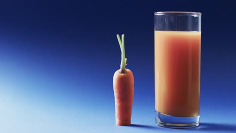 Video-of-carrot-and-carrot-juice-with-copy-space-on-blue-background