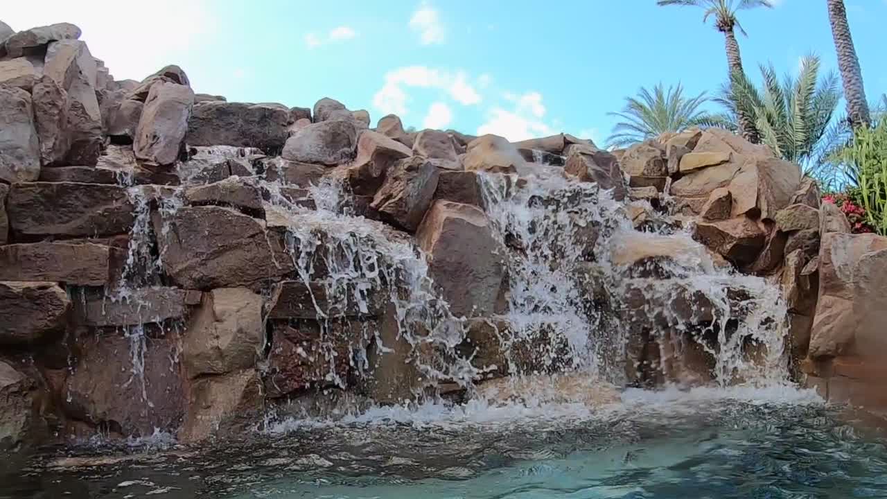 cascada junto a la piscina del hotel en un resort de lujo