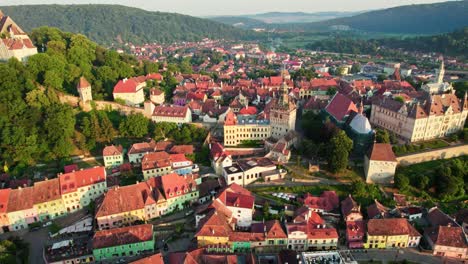 flying around sighisoara city center in morning lights, romania.  aerial sunrise view of old town sighisoara