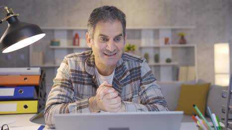 hombre maduro mirando la computadora portátil con anticipación emocionada regocijándose.