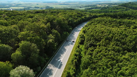 flight over the highway with few cars in the lush woods. drone footage over the wildlife in slovakia
