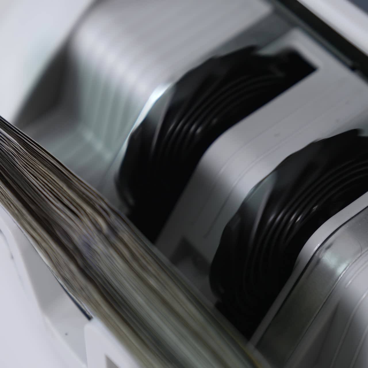 Rotating mechanism turning quickly money in the currency counter machine. One hundred dollars in the slot of apparatus. Close up. Top view