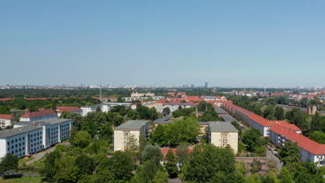 Rising-shot-of-suburbs.-Housing-estate-near-main-railway-track.-Tall-buildings-in-downtown-in-distance.-Berlin,-Germany