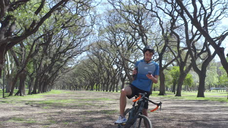 cyclist drinking water and using phone during bike trip