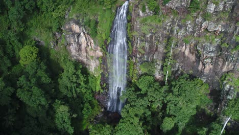 Luftaufnahme-Eines-Wasserfalls-Und-Einer-Klippe-Bei-Sonnenuntergang-Mit-üppigem-Grünen-Wald-Im-Vorder--Und-Hintergrund