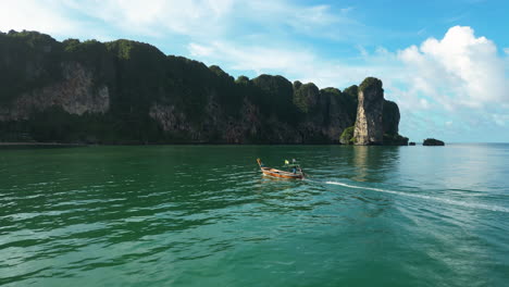 tomada aérea de un barco turístico de crucero local entre ao nang y krabi durante un día soleado en tailandia tropical