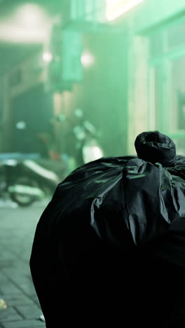 black garbage bag on a city street at night