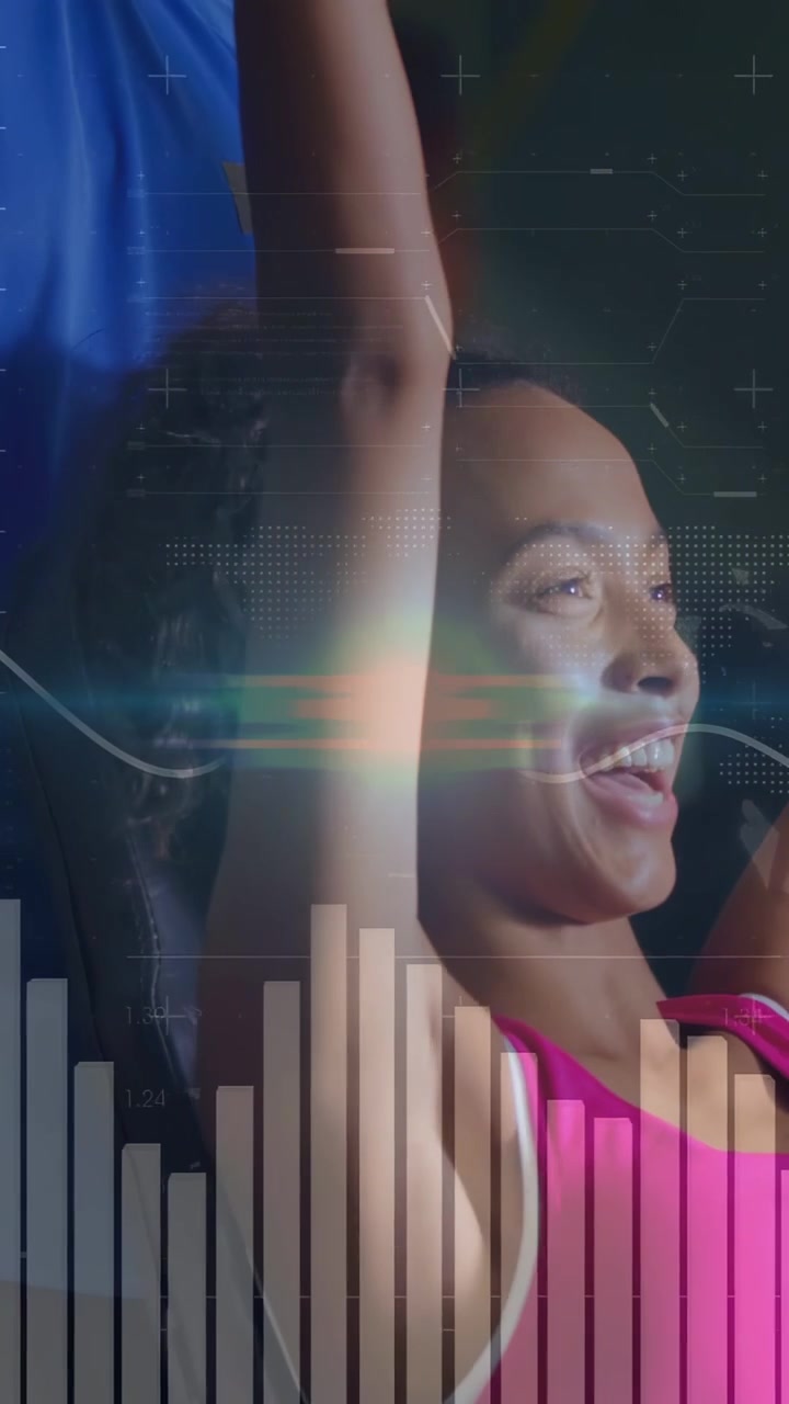 Vertical video: Woman pressing hex dumbbell overhead while coach spotting HUD health metrics rising