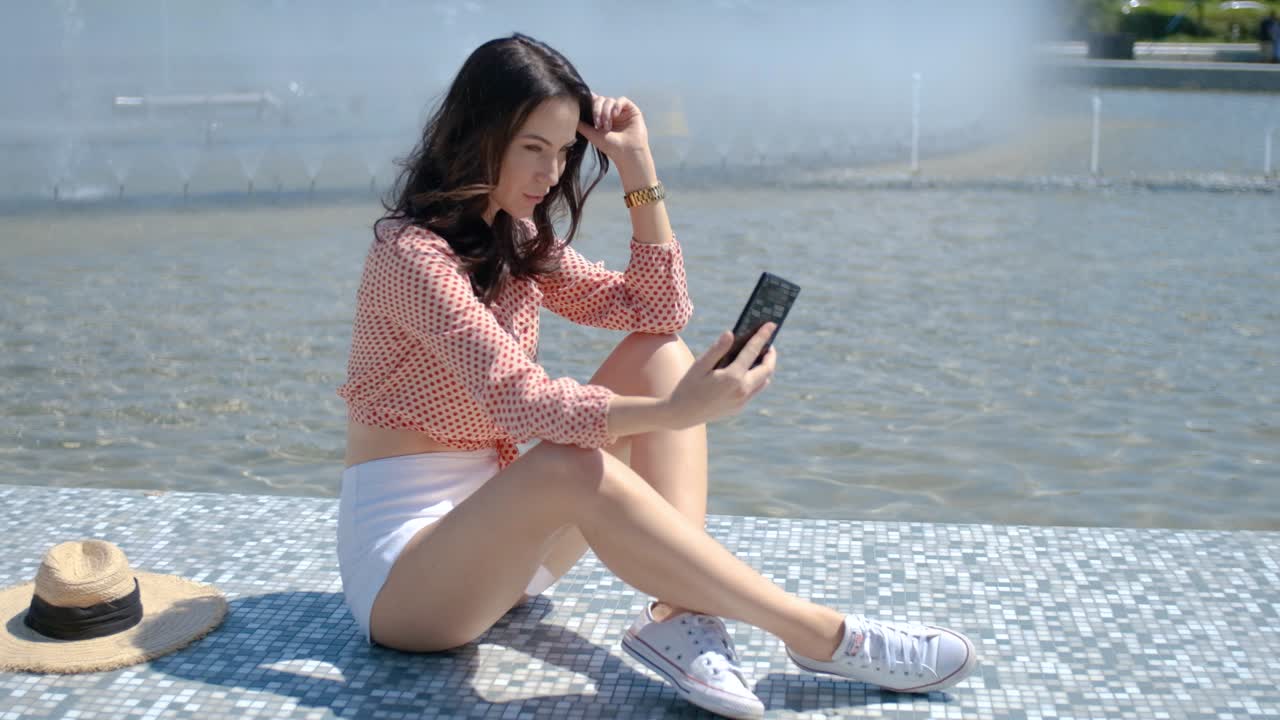 그녀의 휴대 전화로 셀카 사진을 찍는 예쁘고 섹시한 여자