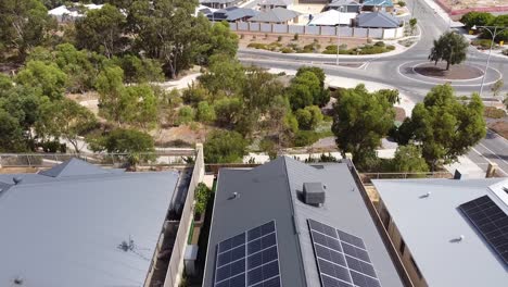 house solar panels with vehicles, trees and buildings background, aerial