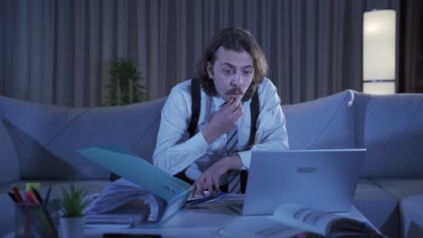 Young-businessman-looking-focused-on-laptop-at-home.