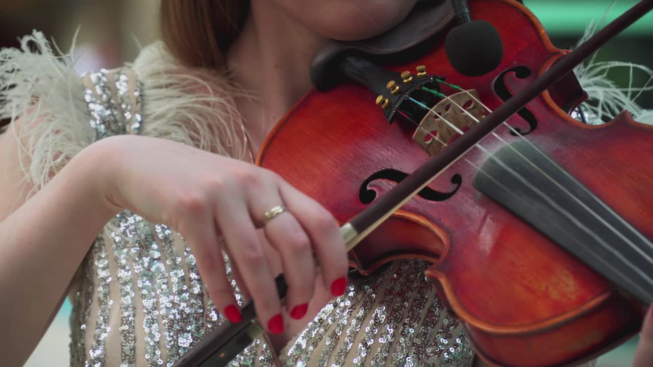 Woman masterly plays the violin at the wedding ceremony 03