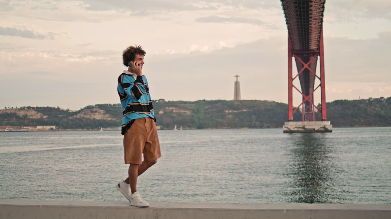 포르투갈 시에서 휴대전화로 전화하는 긍정적 인 스터. 유명한 장소에서 는 남자