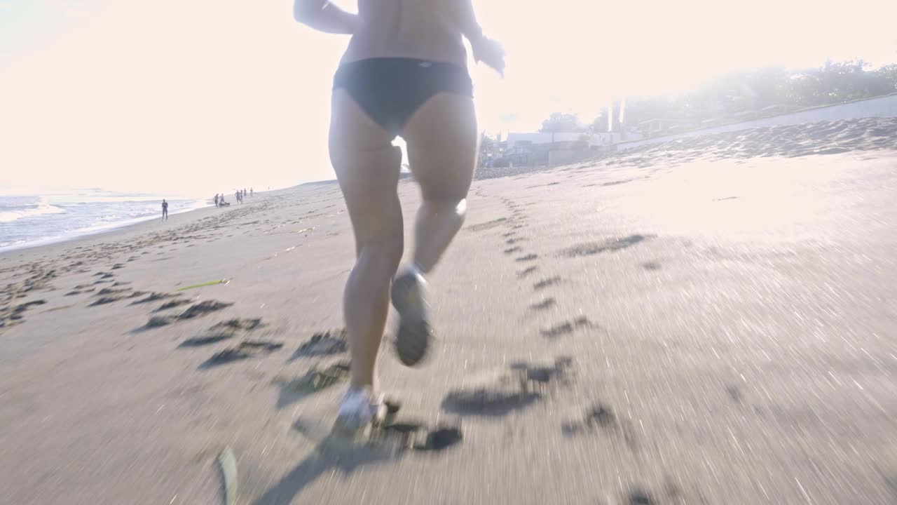 mujer corriendo a lo largo de la playa por la mañana