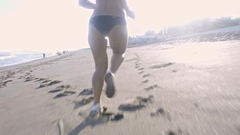 woman running along beach in morning
