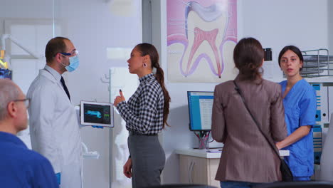 médico sosteniendo la tableta con rayos x mostrándola al paciente