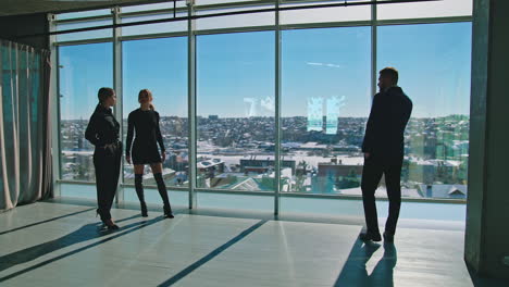 business people at work break near office window. beautiful young women having a conversation in modern office. businessman in suit talking through the phone.