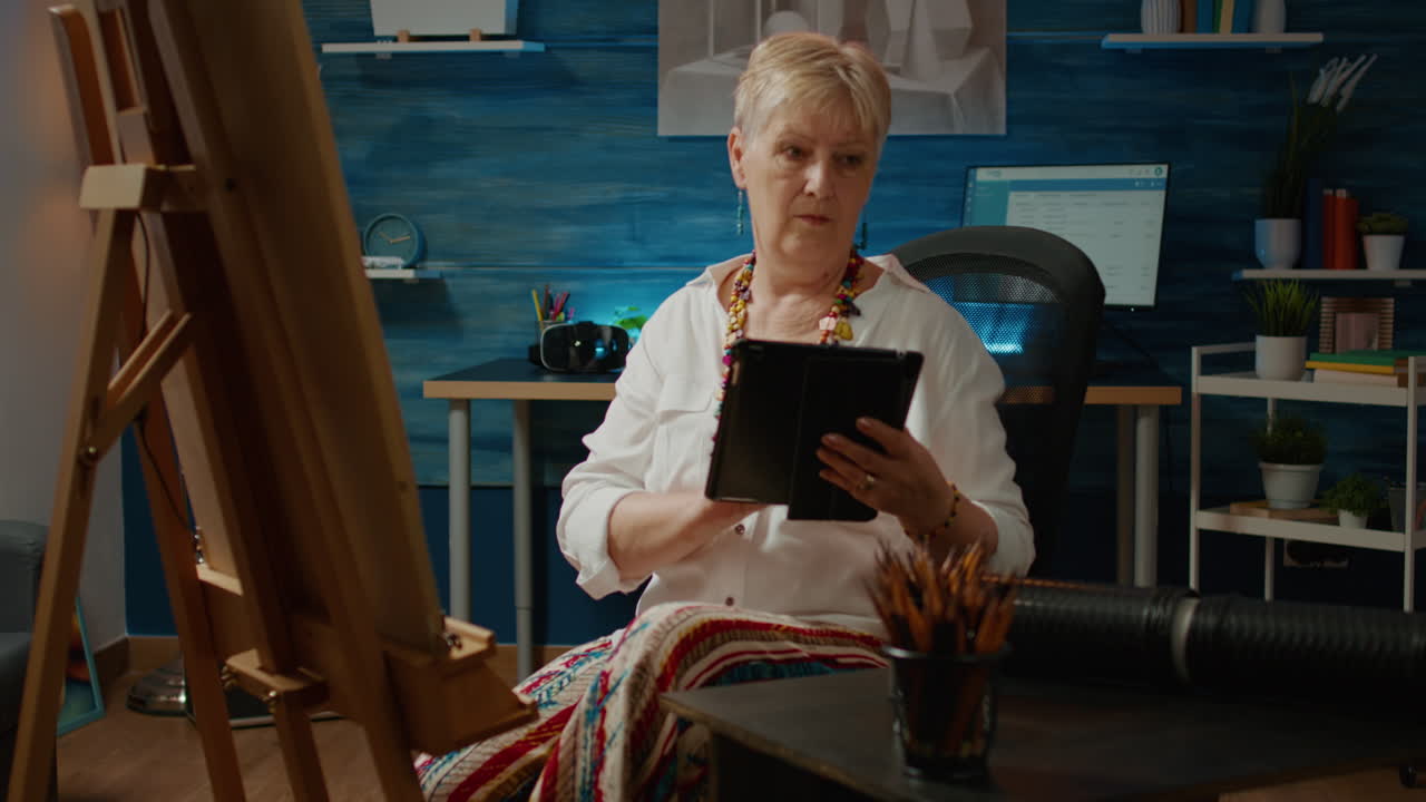 Retired adult looking at drawing inspiration on digital tablet