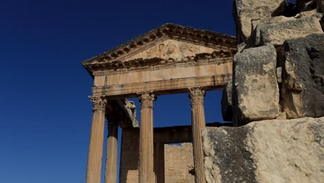 Sunlit-ancient-Roman-ruins-in-Dougga-against-a-clear-blue-sky