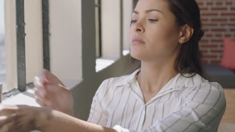 Hermosa-Mujer-Hispana-Usando-Un-Teléfono-Inteligente-Bebiendo-Café-En-Casa-Disfrutando-De-Una-Mañana-Relajada-Navegando-Mensajes-Mirando-Por-La-Ventana-Pensando-Contemplativamente