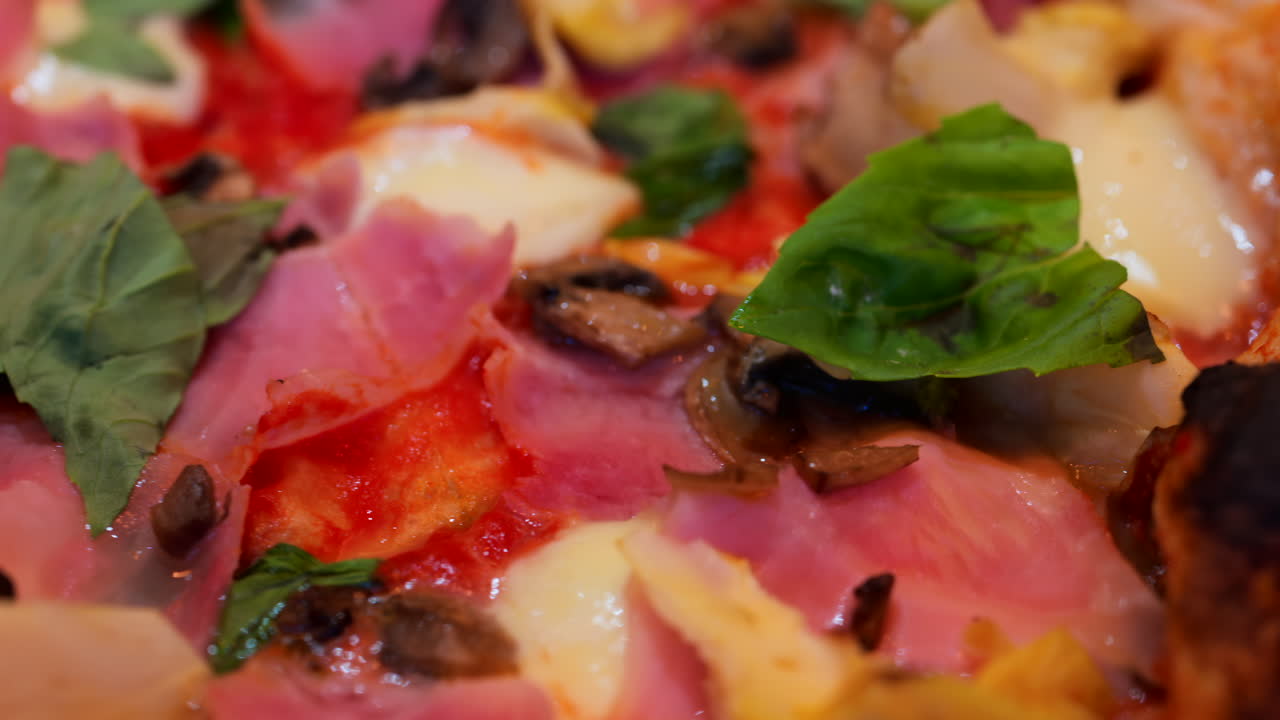 Close up of pizza with artichoke, ham, mushrooms and basil