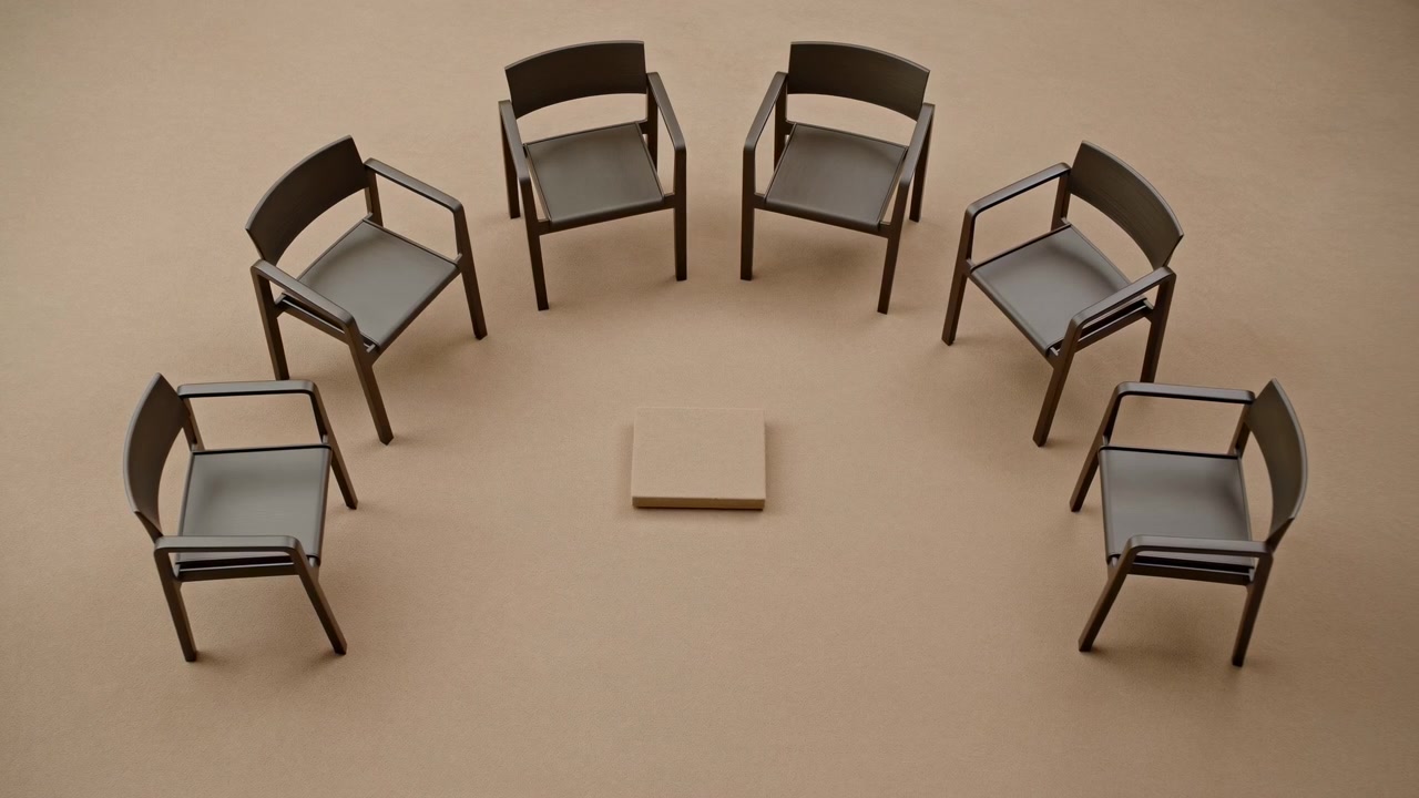 Overhead view shows six empty dark chairs arranged in loose circle around small square block on plain beige floor, with soft diffused light, subtle shadows, clean geometry, and quiet business mood