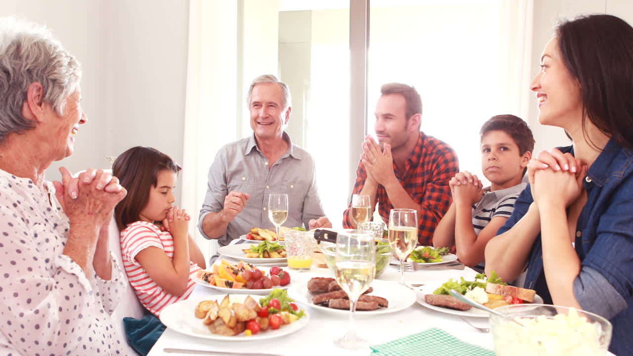 familia orando antes de comer el almuerzo