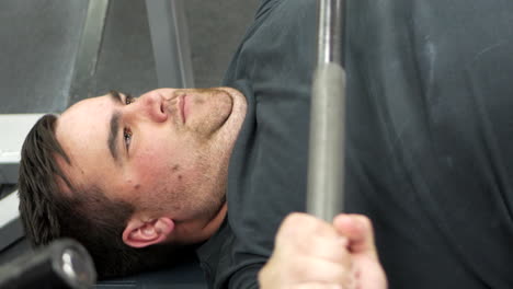 close up of a man performing a bench press set during a weight training session