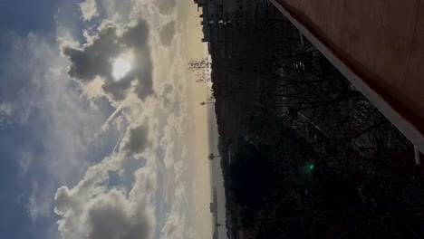 Puesta-De-Sol-Detrás-De-Nubes-De-Autos-Ciudad-Y-Costa-En-Cascais-Portugal,-Timelapse-Vertical