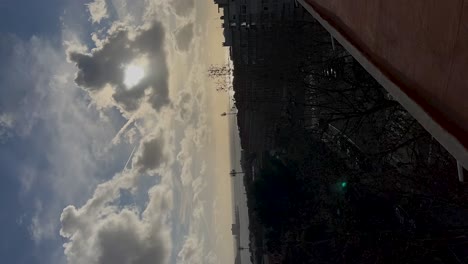 puesta de sol detrás de nubes de coches ciudad y costa en cascais portugal, time-lapse vertical