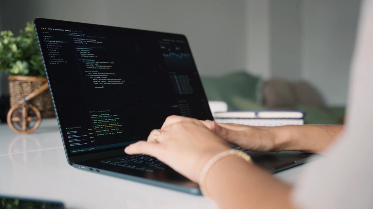 Softwareentwickler schreibt Code auf Laptop im Homeoffice.