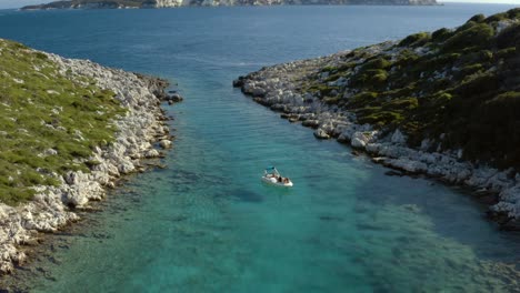 boat in ionian sea lagoon on paxos island coast in greece, aerial