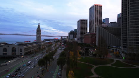 San-Francisco,-USA,-Luftaufnahme-Des-Historischen-Fährgebäudes,-Verkehr-Auf-Dem-Bay-Trail,-Gebäude-Der-Embarcadero-Plaza-Nach-Sonnenuntergang,-Drohnenaufnahme